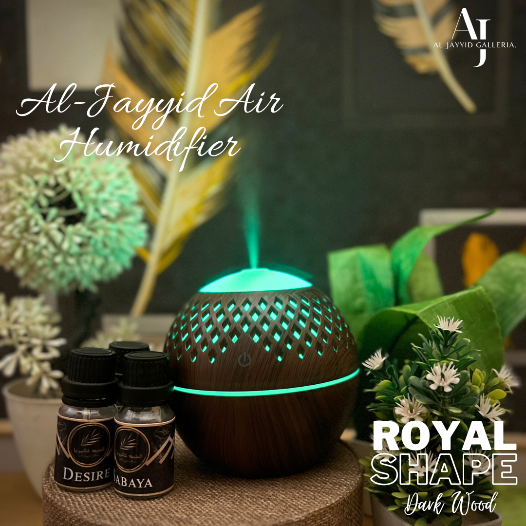 Al Jayyid Air Humidifier royal shape in a dark wood colour with 3 fragrance bottles placed on a craft box.