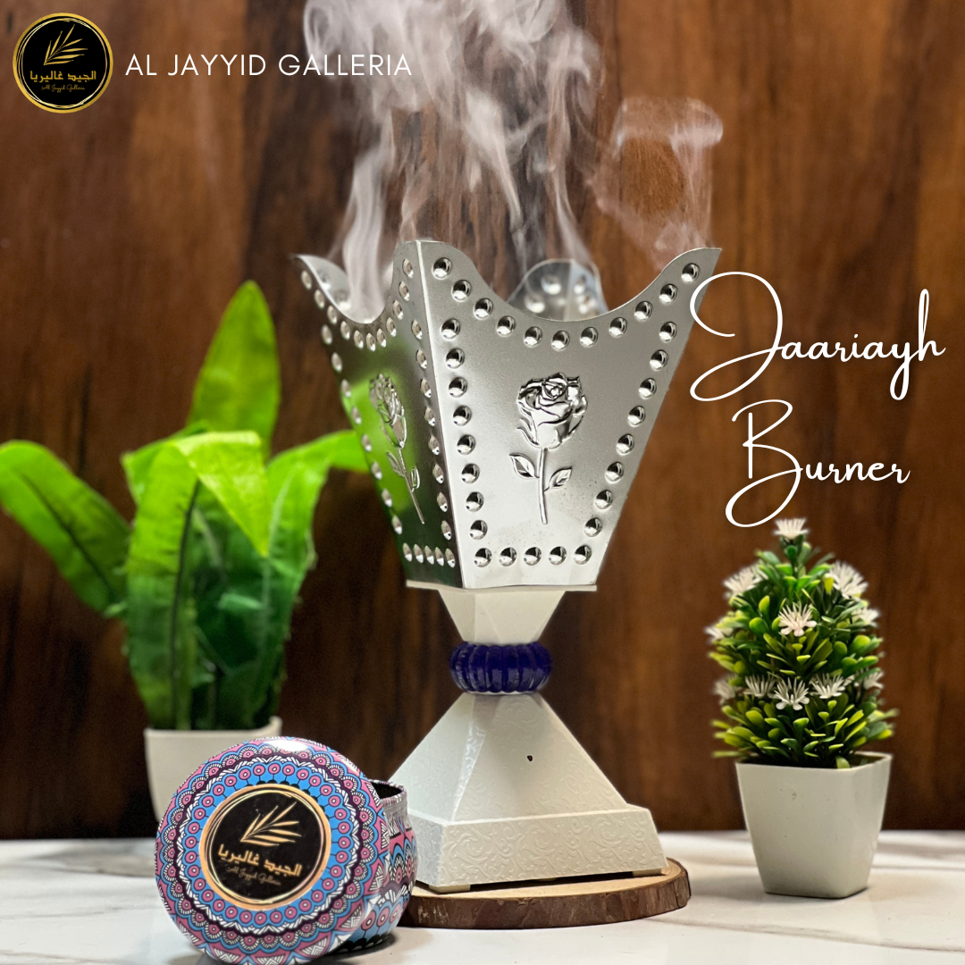 Jaariyah 'جاریہ'  Electric Bakhoor Burner in silver color with bakhoors placed on a marble surace by Al Jayyid Galleria
