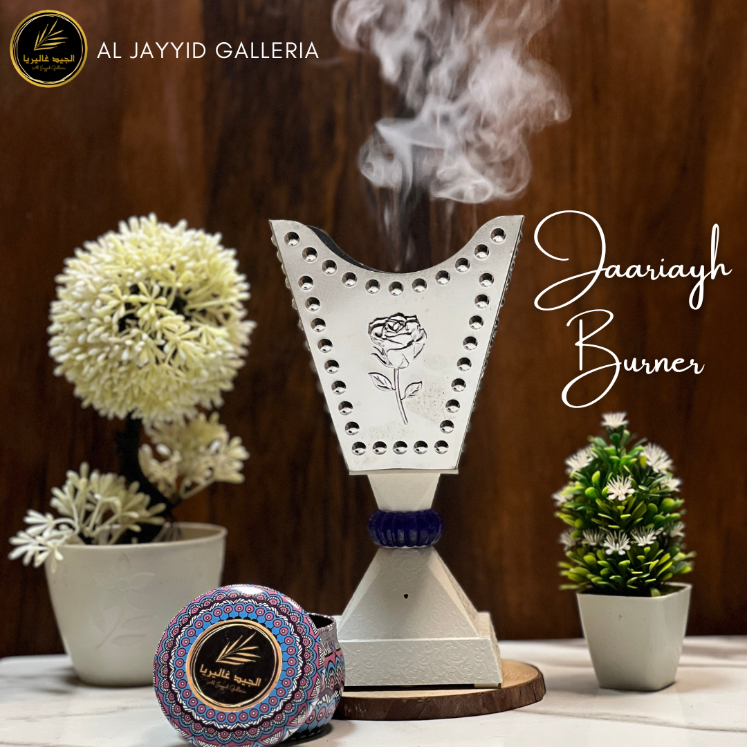 Jaariyah 'جاریہ'  Electric Bakhoor Burner in silver color with bakhoors placed on a marble surace by Al Jayyid Galleria
